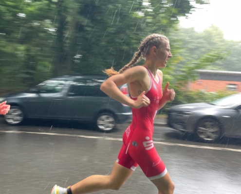 Emily kämpft sich bei ihrem ersten Rennen im roten Einteiler durch den Regen