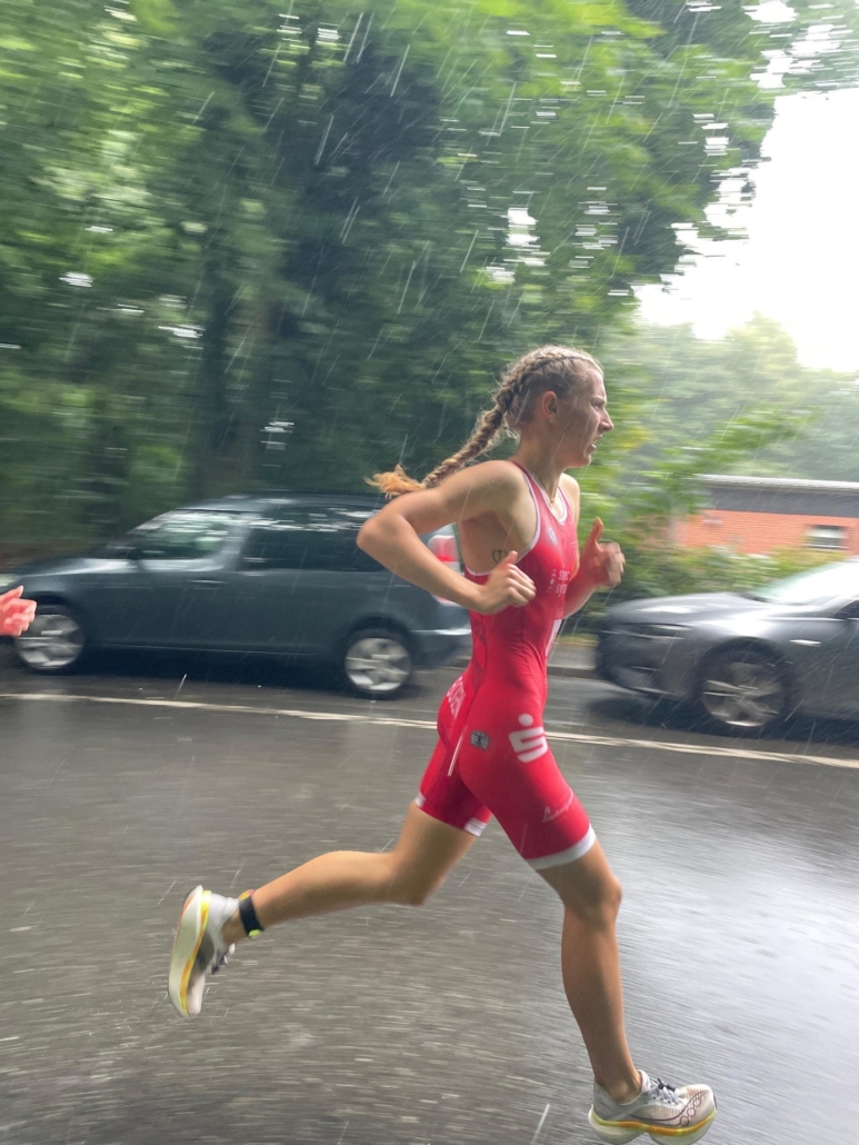 Emily kämpft sich bei ihrem ersten Rennen im roten Einteiler durch den Regen